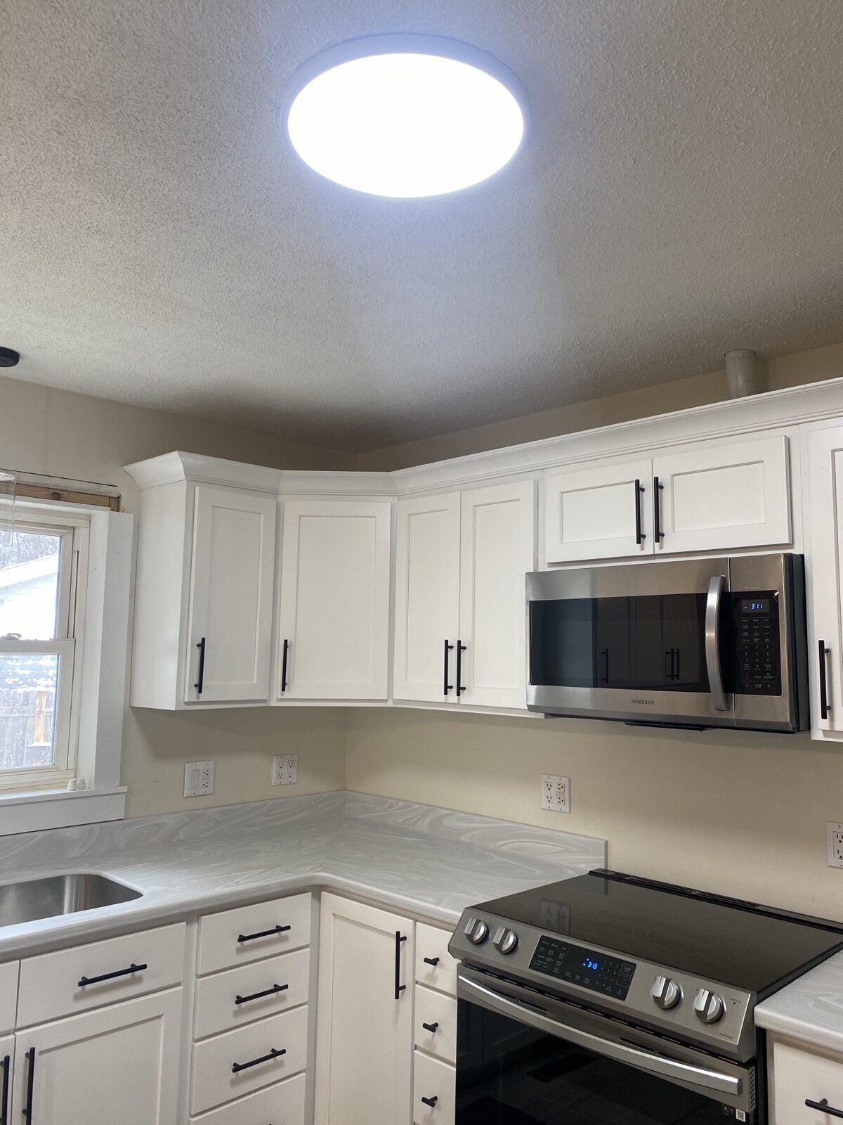 Bright kitchen with white cabinets and a window